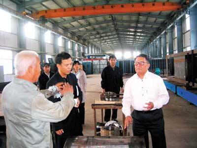 討論長(zhǎng)環(huán)型齒條抽油機(jī)的試制(右一為顧心懌)