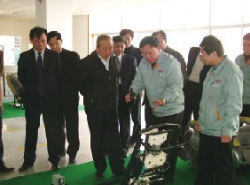 康炳元（右前二）在給客商講解“榮康”按摩椅磨損試驗