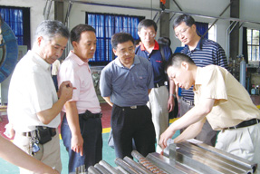 武松濤（右一）向來(lái)賓展示高溫超導(dǎo)材料